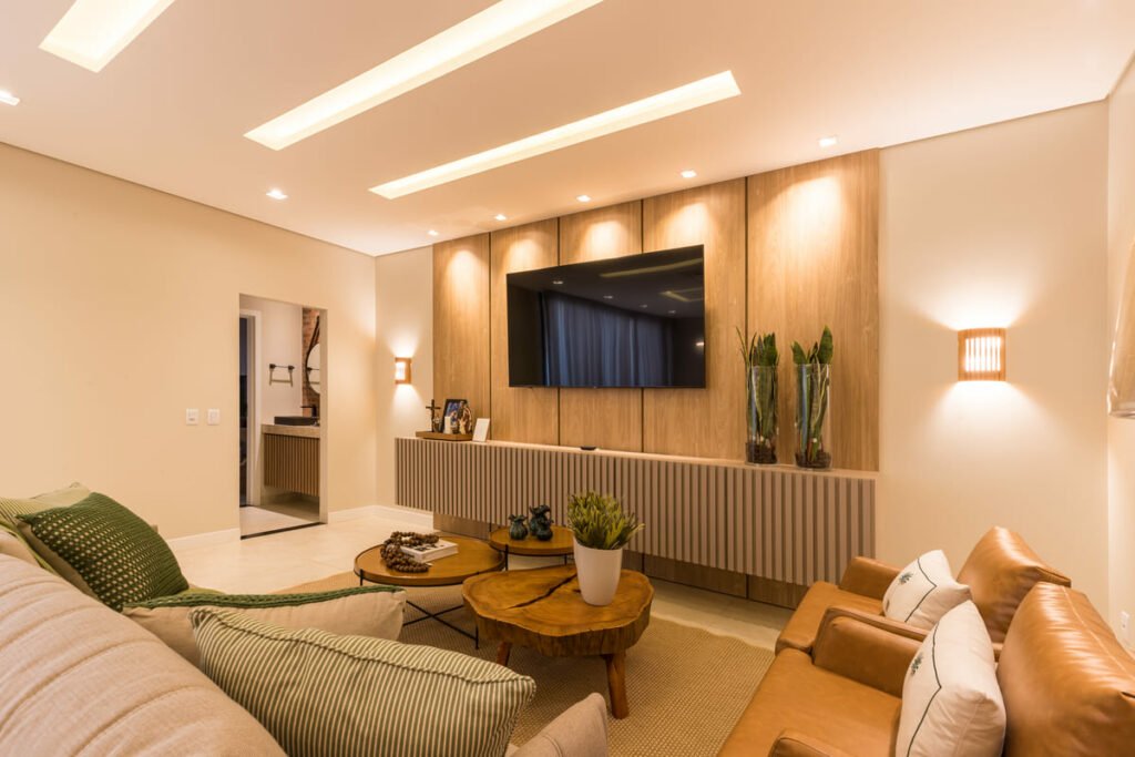 Sala de estar com iluminação em painel de madeira, spots focais e arandelas Accord