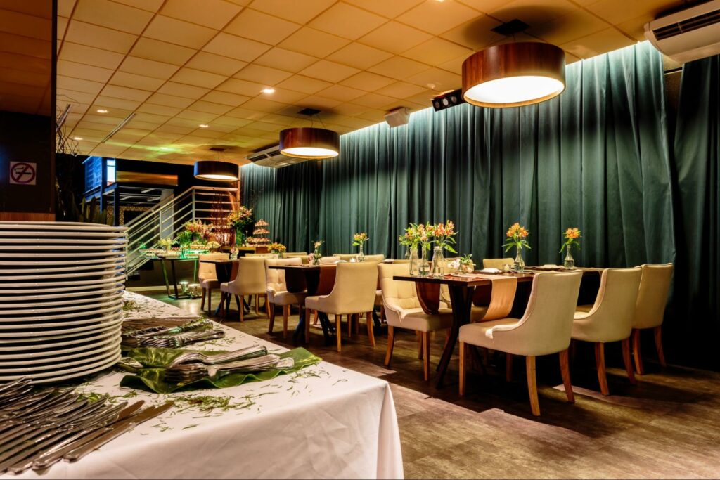Interior de restaurante com mesa de buffet em primeiro plano e plafon Accord sobre mesas