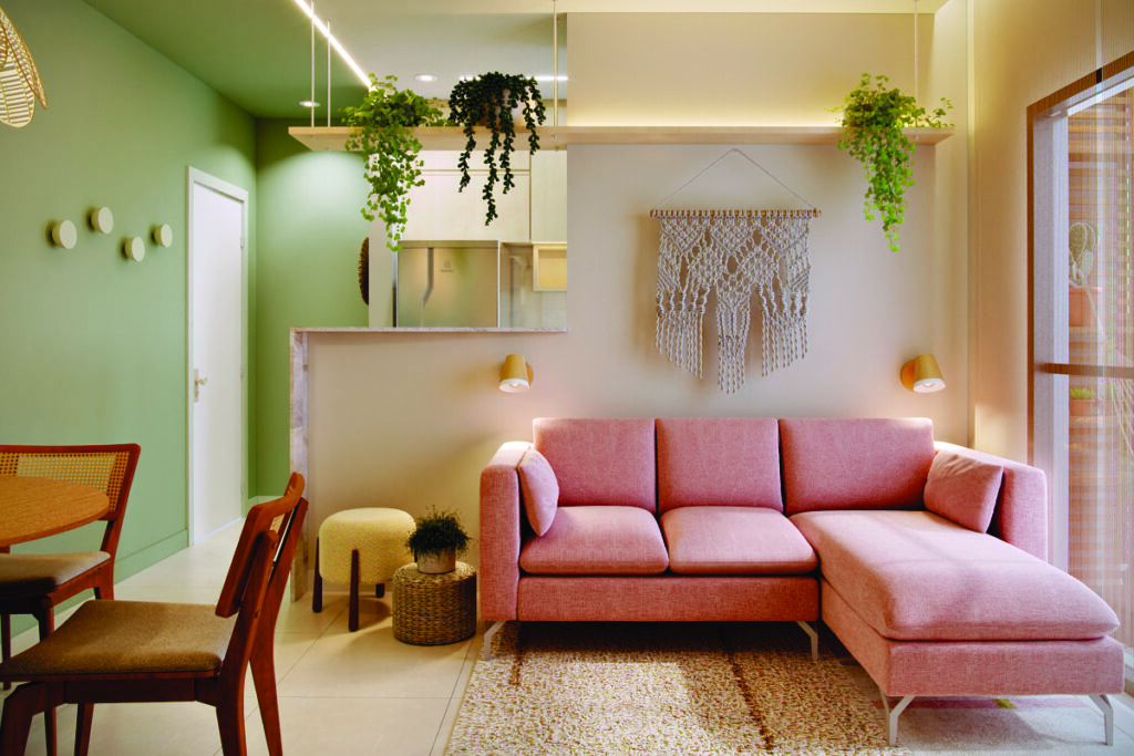 Sala de apartamento com parede verde e sofá rosa e luminárias Accord